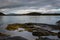 Rocky coastline in Oban bay on a stormy sunrise, Scotland