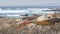 Rocky craggy ocean coast, sea waves, Monterey California. Wooden empty bench.