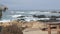 Rocky craggy ocean coast, sea waves, Monterey California. Wooden empty bench.