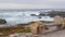 Rocky craggy ocean coast, sea waves, Monterey California. Wooden empty bench.