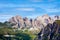 Rocky dolomitic mountains and green valley on a summer day with some clouds