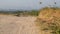 Rocky, dry and barren dirt road, weed grassland in summer