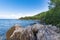 Rocky eastern coast of Lake Baikal in summer. Turquoise colored water under a blue sky. Republic of Buryatia, Russia