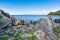 Rocky eastern coast of Lake Baikal in summer. Turquoise colored water under a blue sky. Republic of Buryatia, Russia