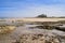 The rocky foreshore and sandy beach with Bamburgh Castle in the background