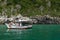 Rocky formation at the seaside with lots of vegetation on top, beautiful sea and boat, Cabo Frio, Brazil