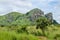 Rocky green mountain range with lush grass in foreground in landscape in northern Angola, Africa