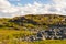 A rocky hill with grass and moss.