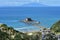 Rocky islet and island in distance