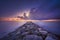 Rocky jetty and thunderstorm on the horizon. Marina di Cecina beach, Tuscany, Italy