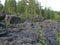 A rocky landscape with trees and rocks in the foreground. Waterfall Poor Porog, Girvas