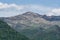 A rocky layered summit standing above a dense forest