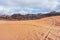 Rocky massifs on red desert, vehicle tracks prints in sand, typical scenery in Wadi Rum, Jordan