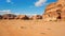 Rocky massifs on red sand desert, bright blue sky in background - typical scenery in Wadi Rum, Jordan