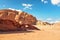 Rocky massifs on red sand desert, small stone arc bridge, bright blue sky in background - typical scenery in Wadi Rum