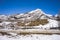 Rocky mountain foothills in snow with blue sky