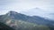 Rocky mountain surrounded by a forest with more mountains in fog in the background,Slovakia, Europe