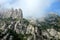 Rocky mountains and clouds and cross at sunny spring day near Montserrat Abbey, Barcelona Catalonia.