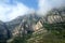 Rocky mountains and clouds at sunny spring day near Montserrat Abbey.