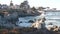 Rocky ocean beach, waves crashing, Monterey, California coast beachfront houses.