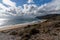 Rocky ocean coast with mountains and a beautiful golden sand beach in the foreground