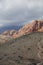 Rocky outcrop and desert plain with cloudy sky.