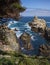 Rocky Promontory into Blue Sea with Cypress Trees and Spring Flowers in California