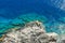 Rocky reef under Lindos acropolis on Rhodos island with blue sea