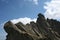 Rocky ridge and peak against blue sky with clouds