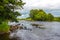 A rocky riffle under trees on a summers day on the River Dee, Galloway, Scotland