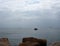 Rocky sea with an empty tourist boat and many windsurfers