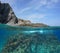 Rocky sea shore above and below water with fish