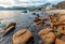 Rocky sea shore of Stanley bay in Hong Kong. Beautiful scenic landscape with water, mountains, rocks, buildings and cloudy sky