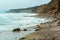 Rocky seashore and high cliff, stormy sea in winter and autumn