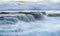 Rocky seashore with wavy ocean and waves crashing on the rocks