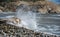 Rocky seashore with wavy ocean and waves crashing on the rocks