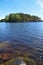 Rocky shore across an island full of trees