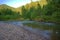 Rocky shore at the bend of a mountain river in the early morning