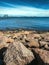 Rocky shoreline and Kattegat sea with Halmstad city industrial seaport in background