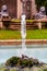 Rocky stone fountain design with clear blue transparent water reflecting the sky and squirt of water flows up under pressure from
