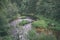 rocky stream of river deep in forest in summer green weather with sandstone cliffs and old dry wood trunks. Amata river in Latvia