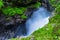 Rocky summer landscape of green forest and powerful streams Slettafossen waterfall. Norway