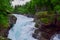 Rocky summer landscape of green forest and powerful streams Slettafossen waterfall. Norway