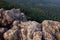 Rocky terrain found on the top peak of a small hill and green natural forest as background landscapes near a  village in India.