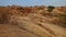 Rocky valley with brown yellow stones and rare bushes