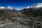 rocky valley in the trekking of the quebrada santa cruz surrounded by high snowy mountains and glacier lagoon in the background