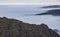 Rocky vertical cliffs of mountains protruding from above over fog and clouds