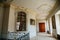 Rococo chateau interior, corridor with paintings, stucco molding on the ceiling and walls, forged wicker lattice on the stairs,