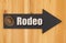 Rodeo type message on a hanging arrow chalkboard sign with a western cowboy hat