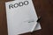 Rodo word on white paper with pen od wood desk.